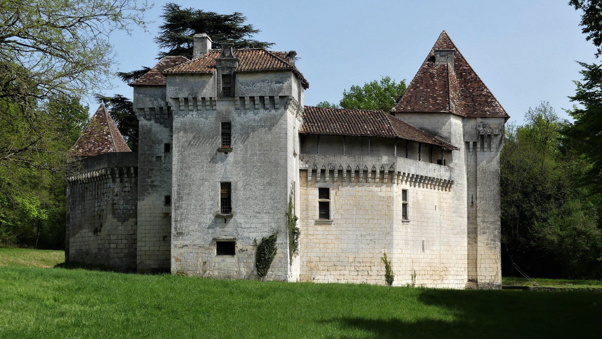 Le château découvert depuis la prairie, à l'orée du bois